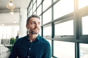 Shot of a mature businessman looking thoughtfully out of an office window