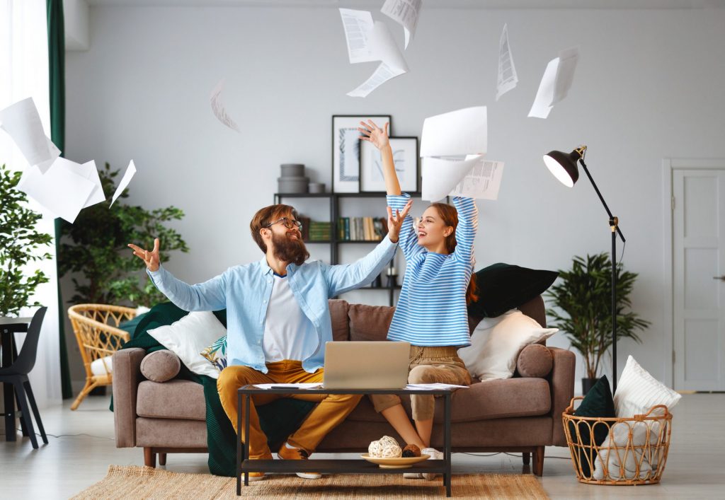 married couple with bills receipts documents and a laptop at home