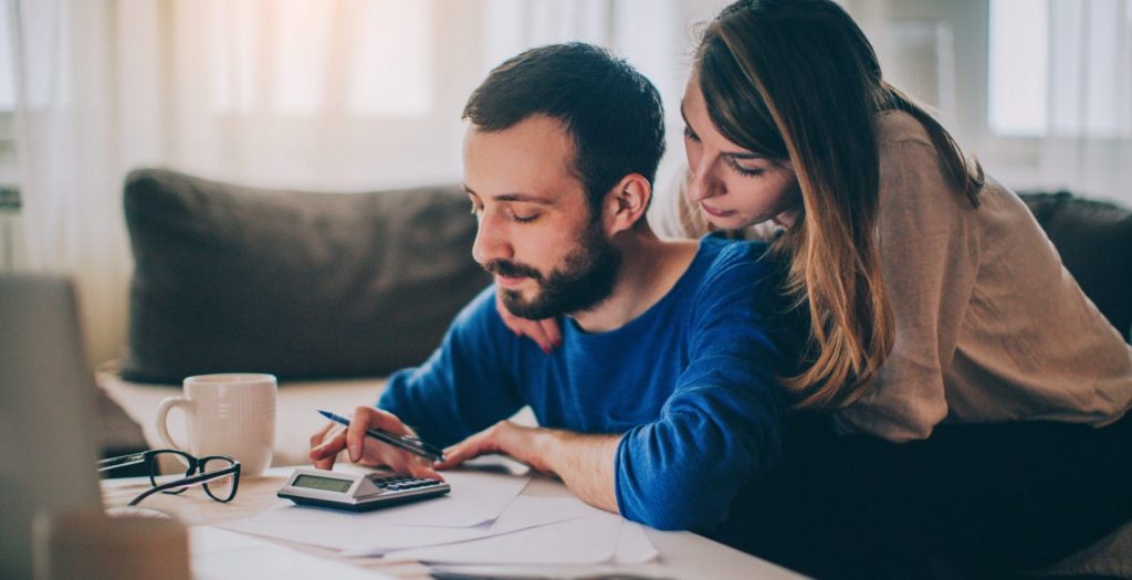 Couple sitting in their living room and checking their finances