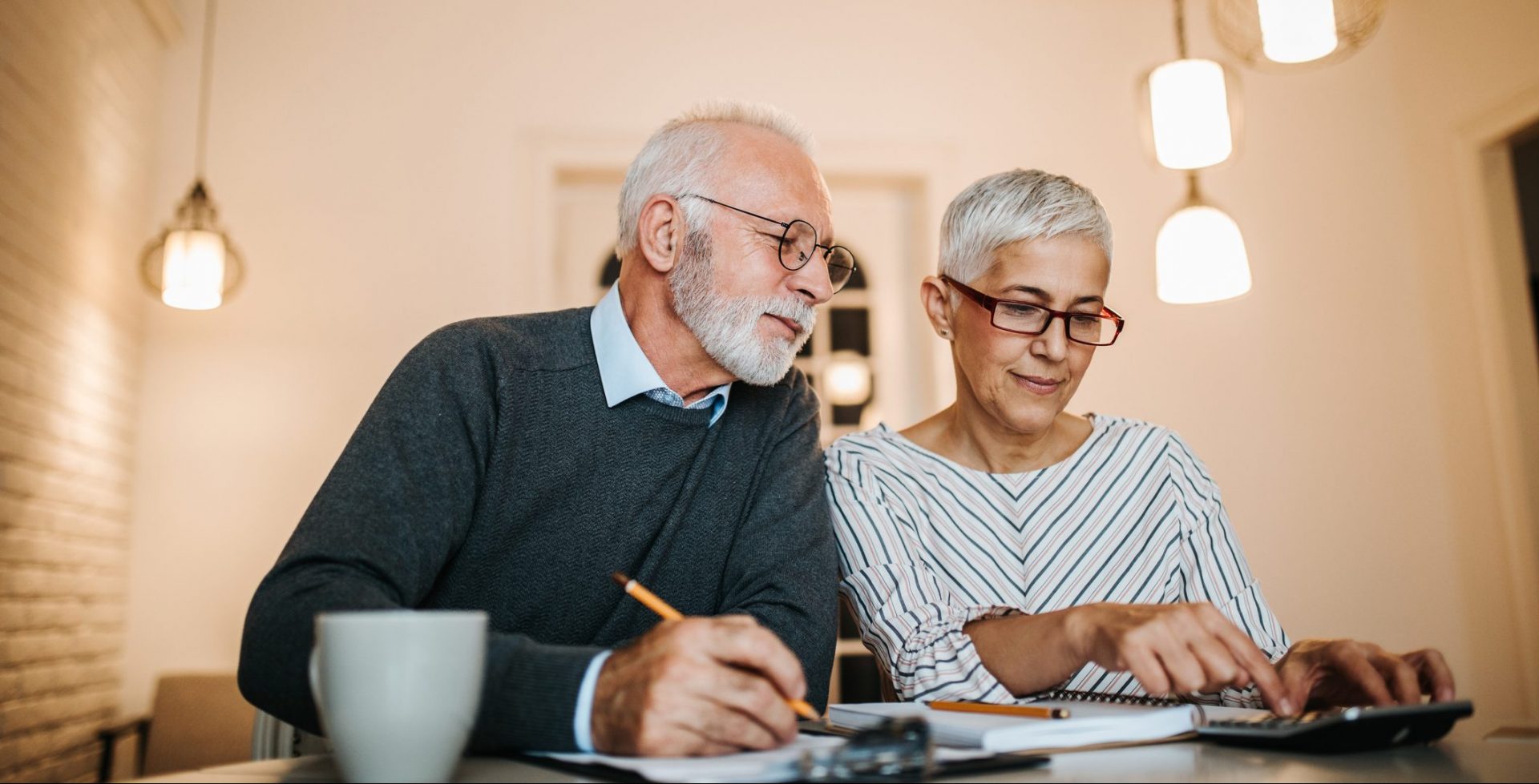 Mature couple doing some paperwork and calculations at home