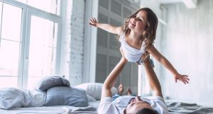 I love you, dad! Handsome young man at home with his little cute girl are having fun together. Happy Father's Day!