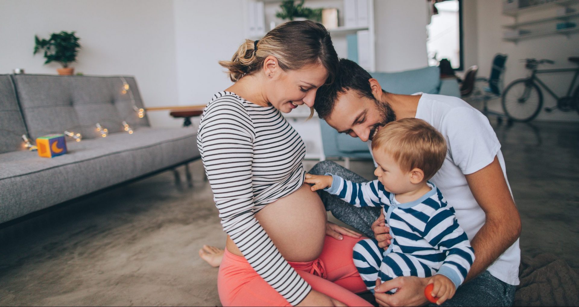Photo of a little boy being curious about his mother's growing belly