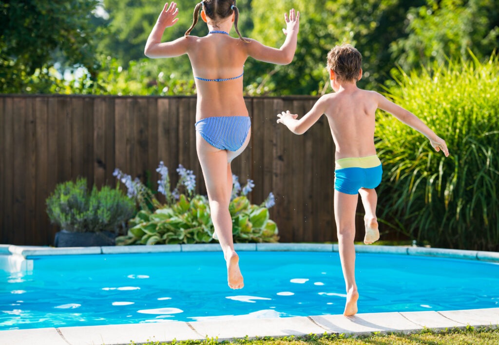 Enfants heureux sautant dans une piscine