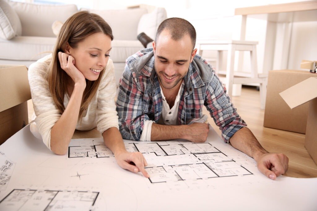 Cheerful couple looking at construction house plan