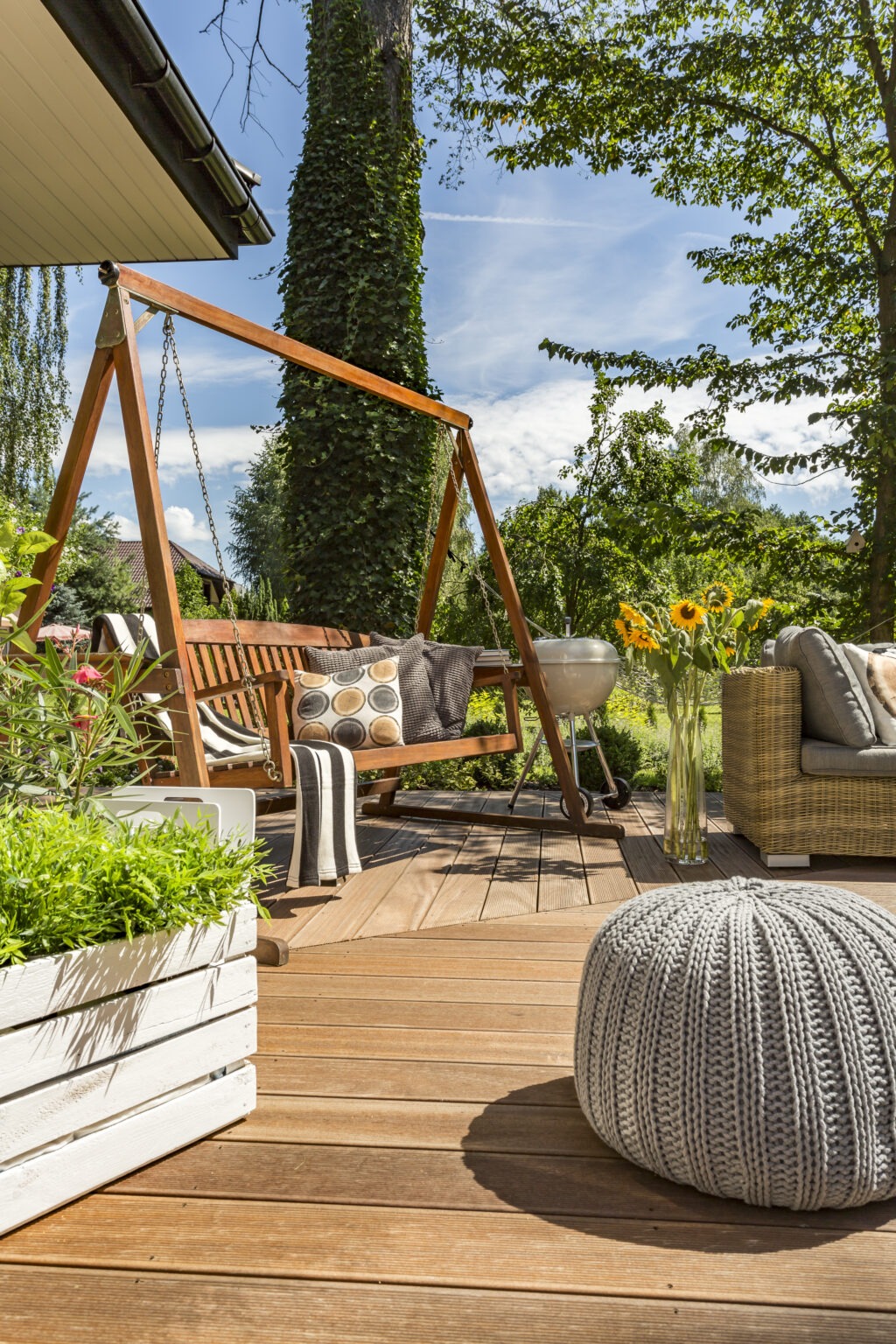New villa patio with garden swing, small pouf and wooden flooring