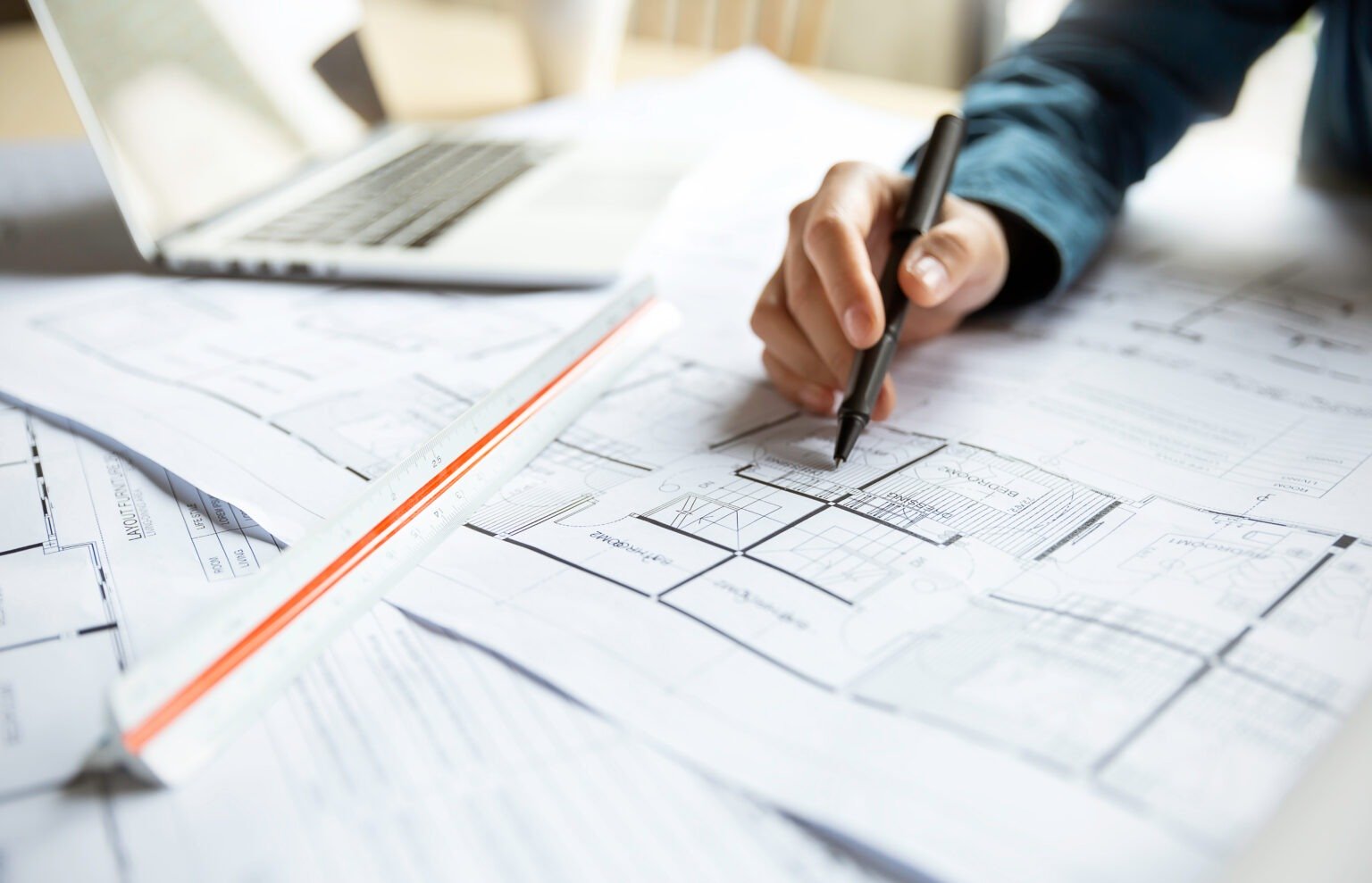 Close up woman hand working of Architect sketching project on blueprint at site construction work. Concept of architect, engineer in the office desk construction project