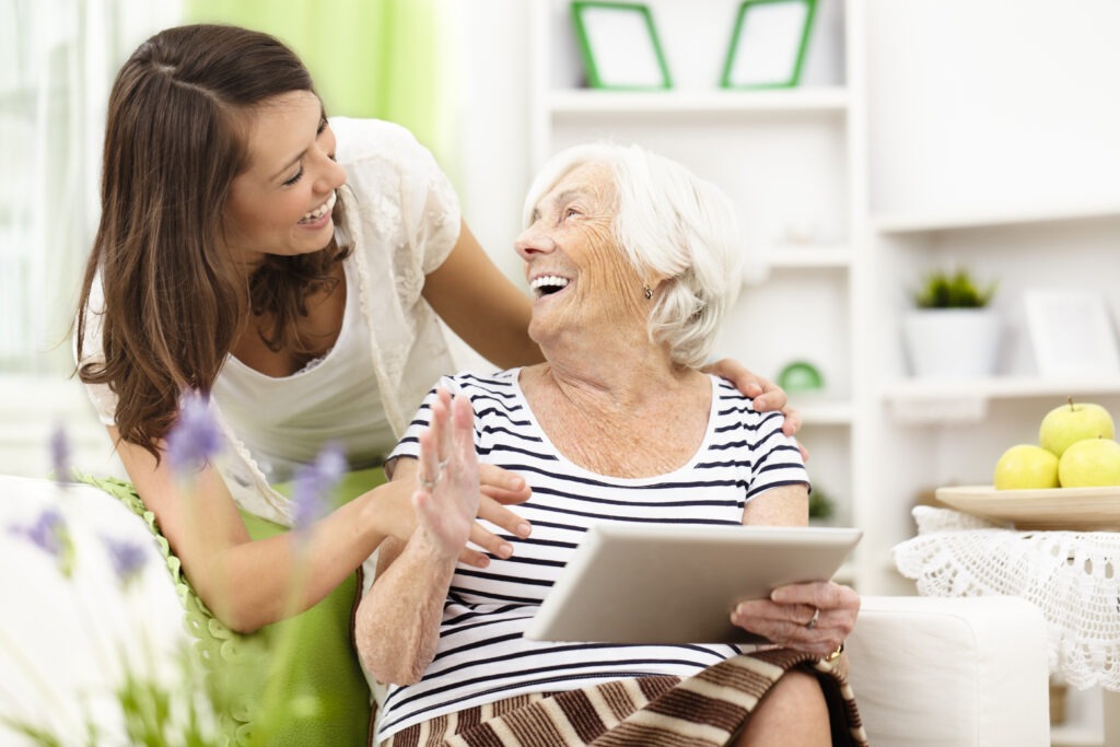 Granddaughter teaching her grandmother to use a tablet