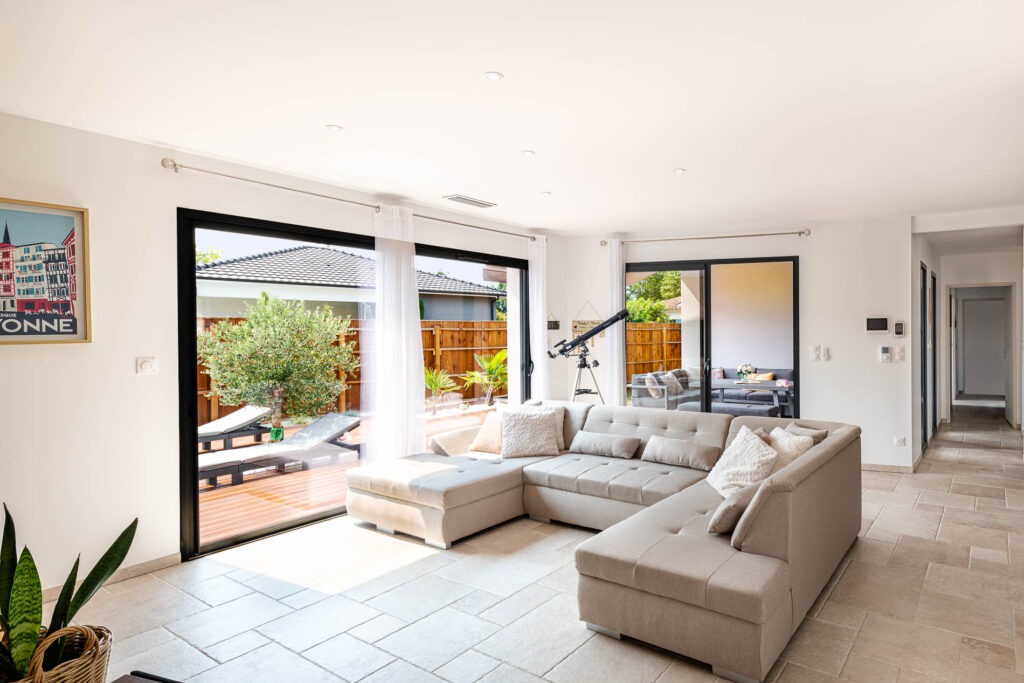 Salon d'une maison avec plan en U, donnant sur le patio extérieur